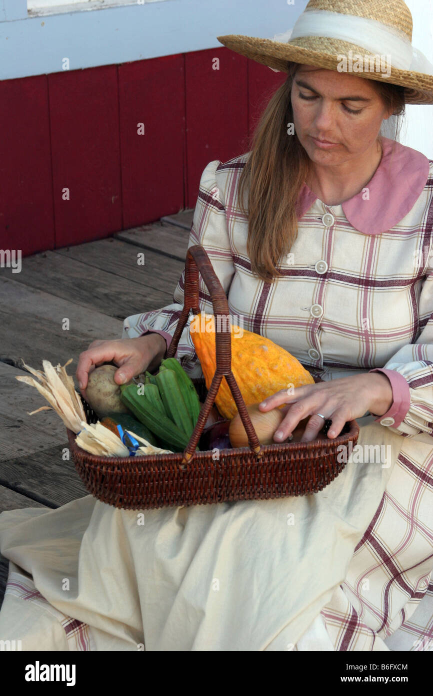 A lady going over her vegetables that she picked while sitting on the porch Stock Photo