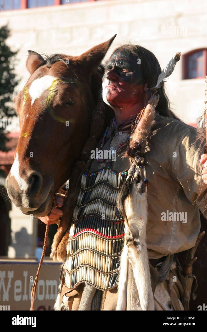 A Comanche Native American Indian posing with his horse and spear at