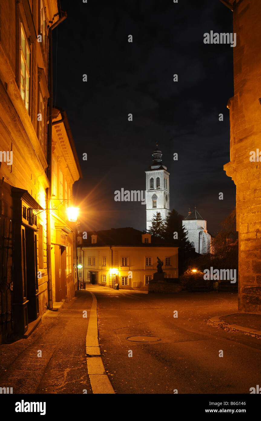 Barborská street in Kutná Hora, Czech Republic. Night view with illuminated st. James Church in the background. Stock Photo