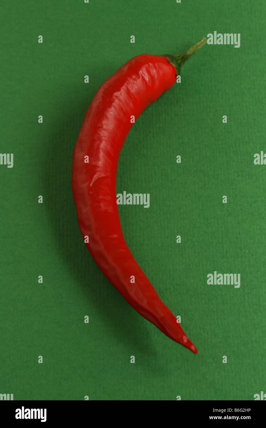 Red chilli pepper on a green background Stock Photo - Alamy