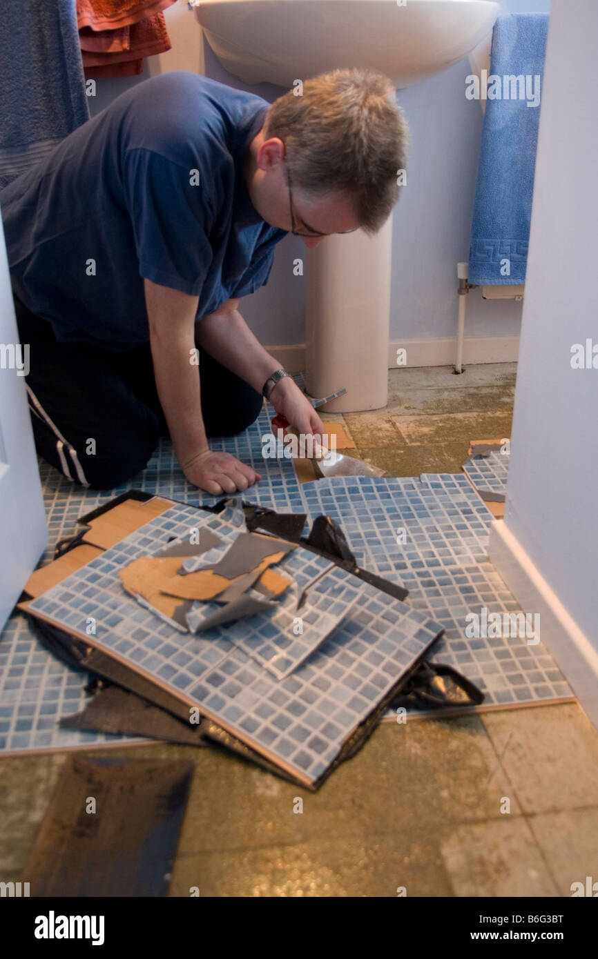 Man replacing tiled bathroom floor in modern british house Stock Photo Alamy