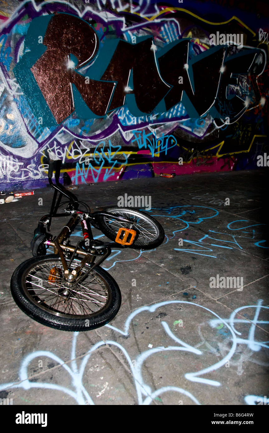 A BMX bike lying on the ground in front of a wall covered in graffiti Stock  Photo - Alamy