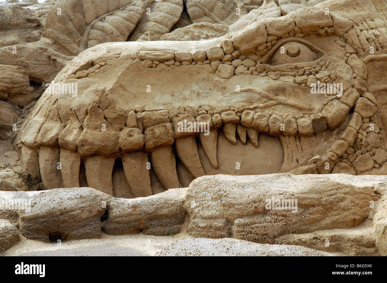 dinosaur head sand sculpture Stock Photo - Alamy