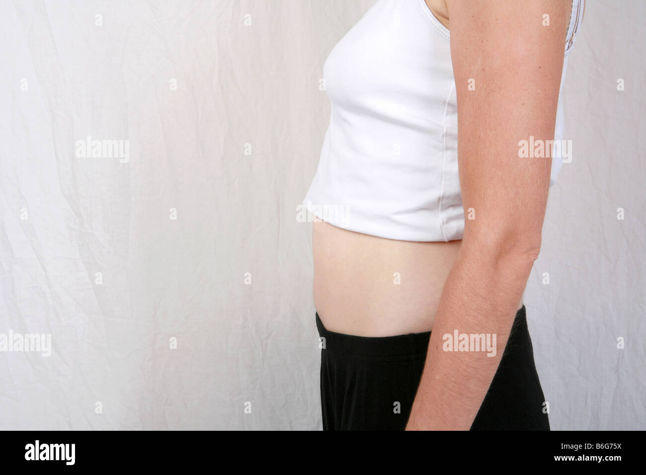 Closeup of pregnant womans stomach bump at 12 weeks 3 months gestation three of a series of ten time lapse pregnancy images Stock Photo