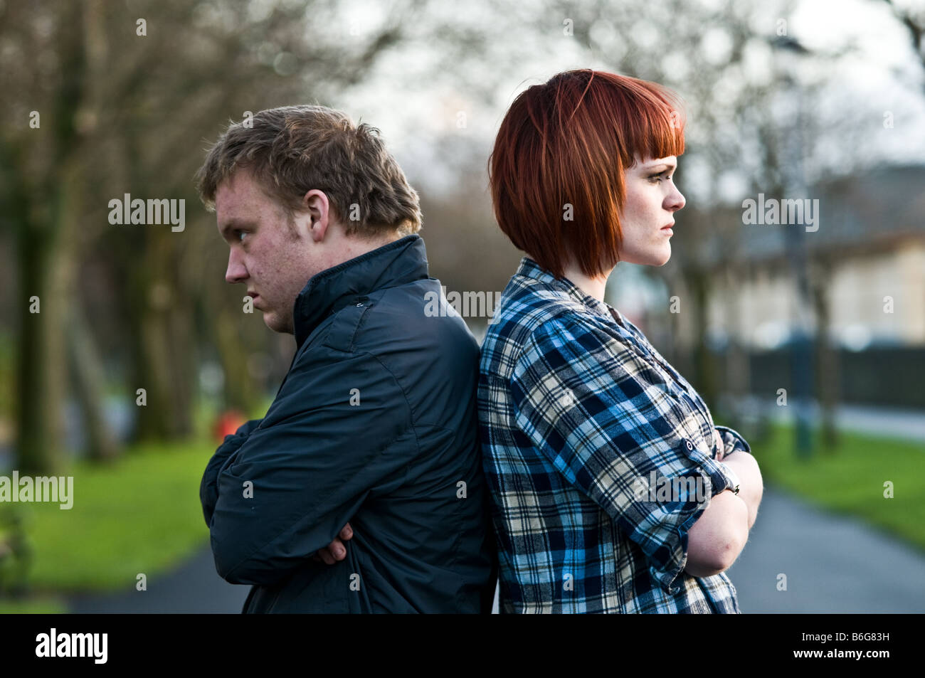 Couple man and woman having an argument standing back to back not speaking to each other Stock Photo