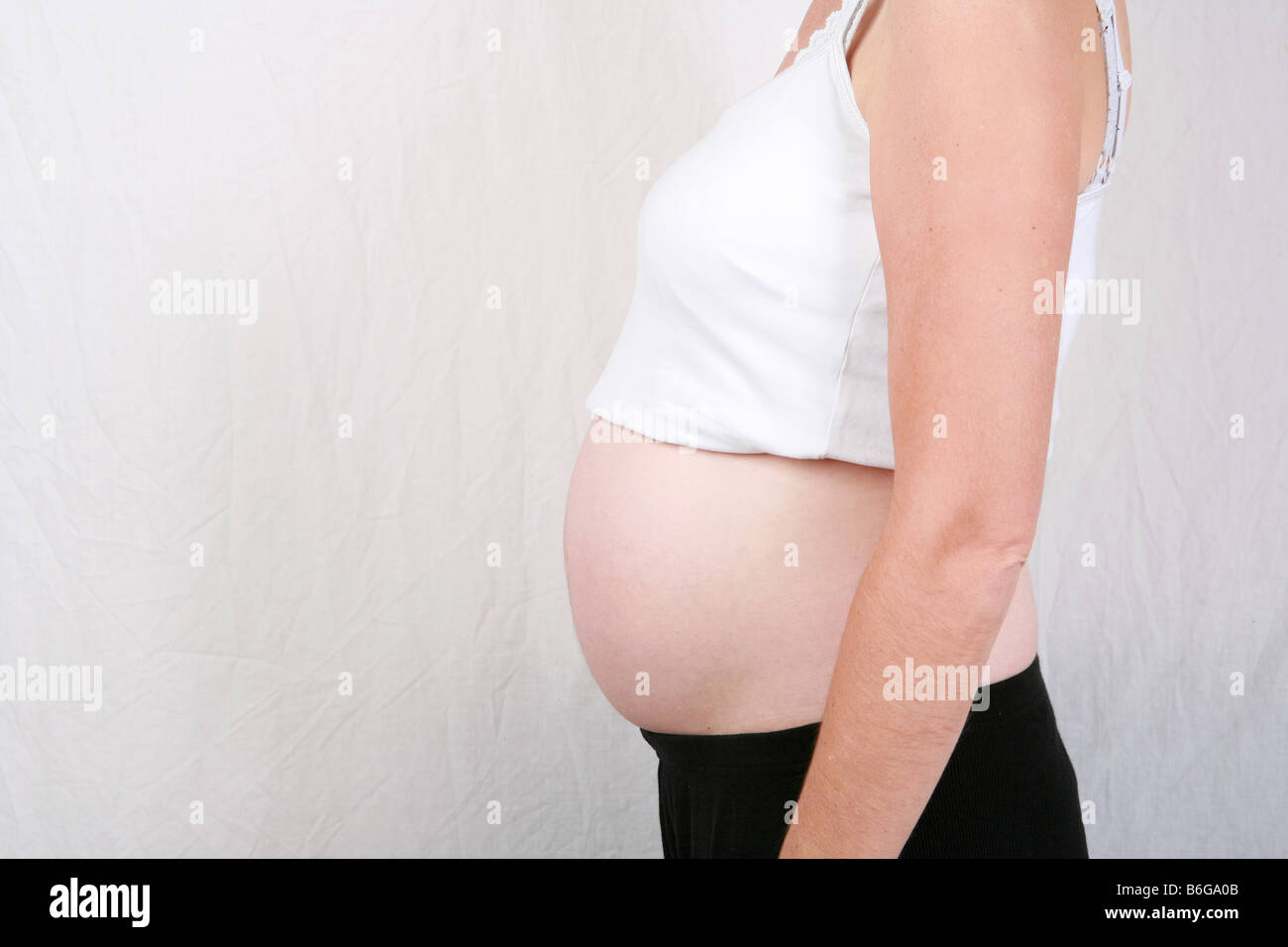 Closeup of pregnant womans stomach bump at 28 weeks 7 months gestation