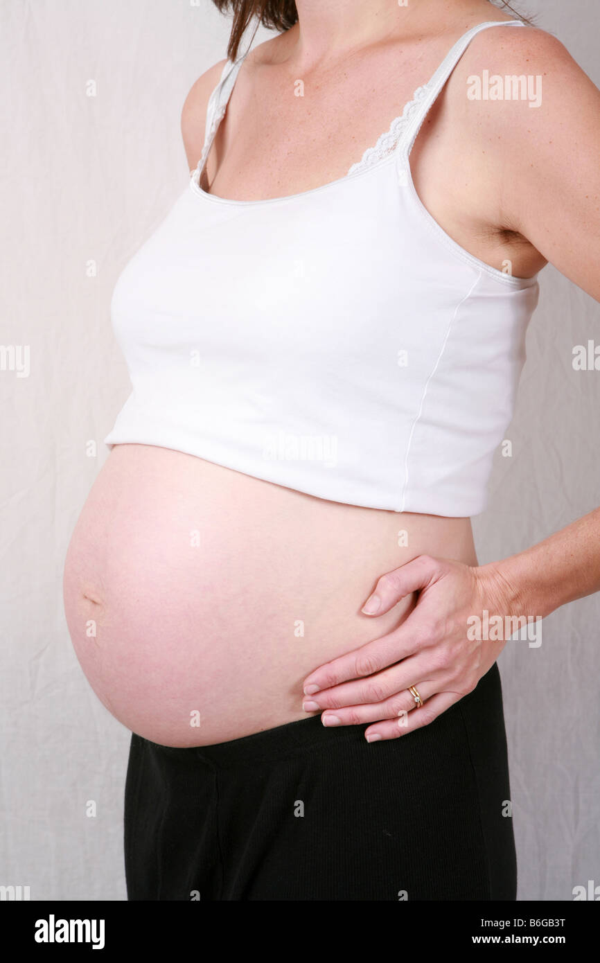 Closeup of pregnant womans stomach bump at 32 weeks 8 months gestation eight of a series of ten time lapse pregnancy images Stock Photo
