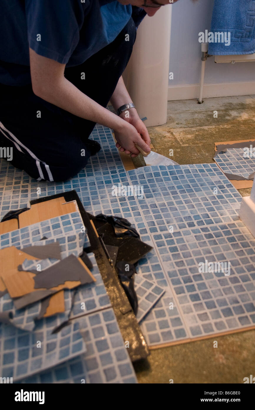 Man replacing tiled bathroom floor in modern british house Stock Photo Alamy