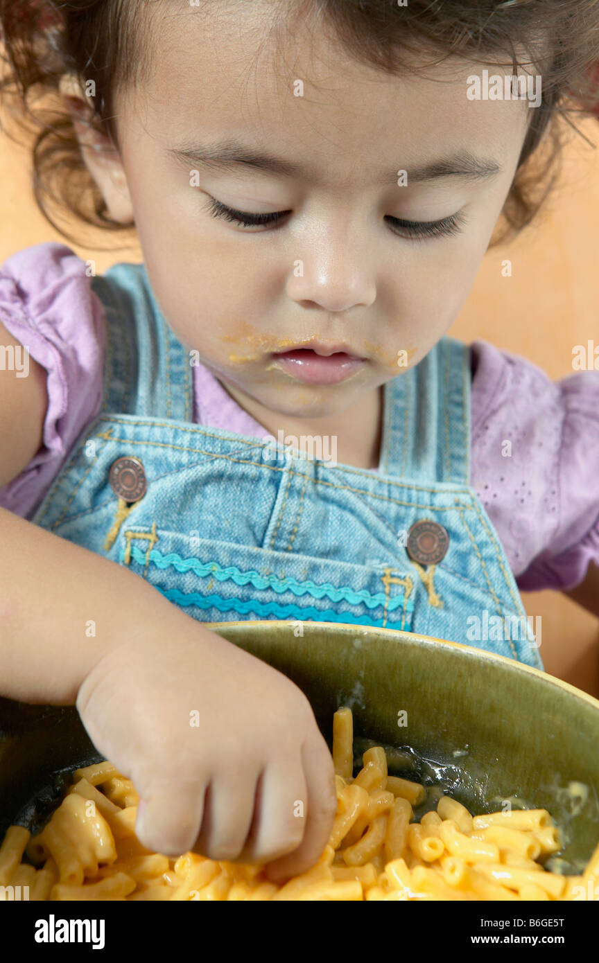Little girl eating macaroni and cheese Stock Photo Alamy