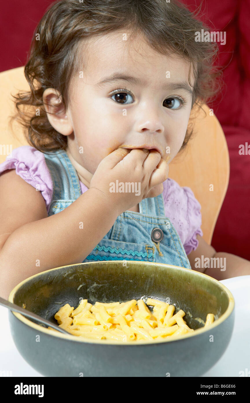 Little girl eating macaroni and cheese Stock Photo Alamy