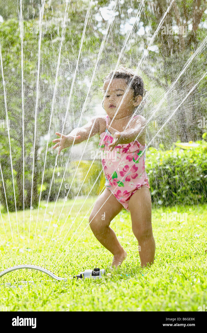 Little girl playing in sprinkler Stock Photo Alamy