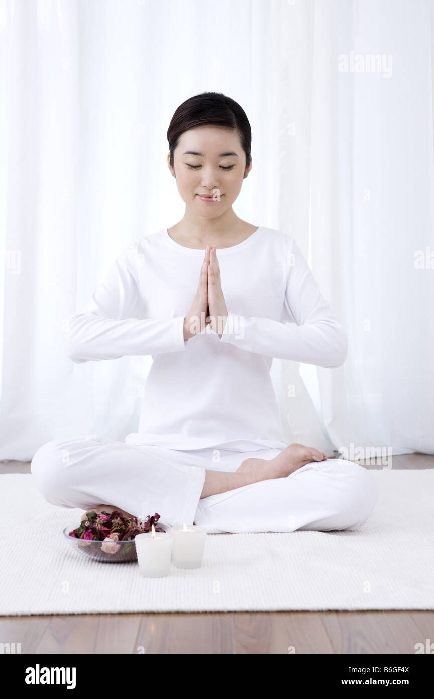 Young woman in prayer position sitting on floor eyes closed Stock Photo ...