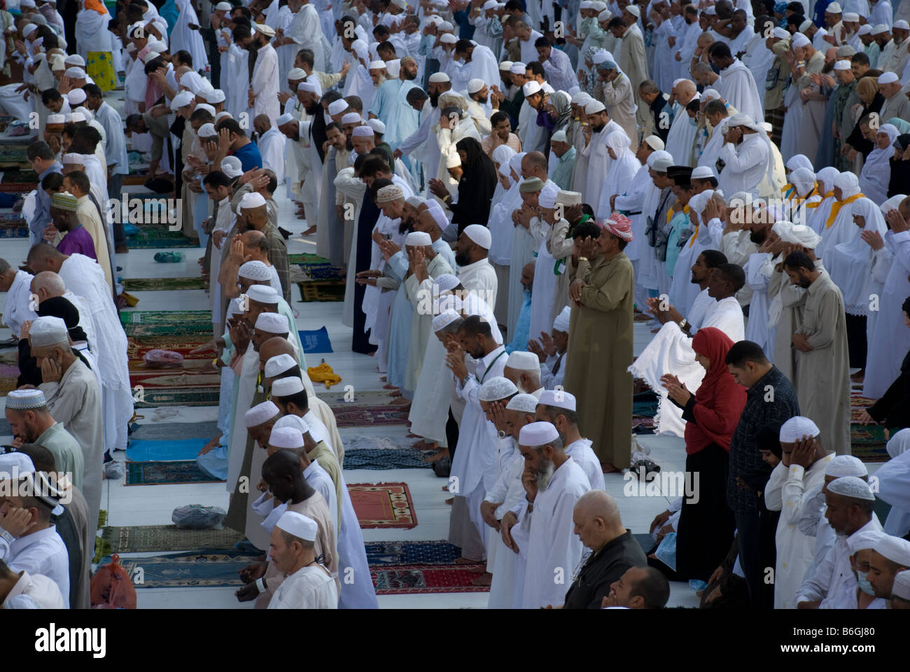 Pilgrims starting to pray the afternoon prayer asr in congregation just outside Masjid al Haram Makkah Saudi Arabia Stock Photo