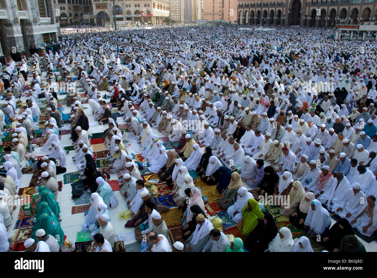 Male and female pilgrims praying the afternoon prayer asr together in congregation just outside Masjid al Haram Makkah Saudi Arabia Stock Photo