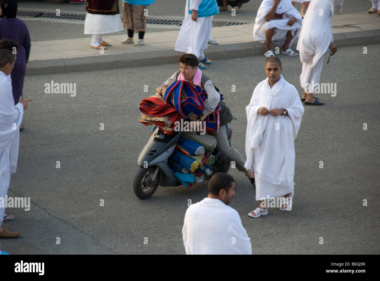 A street seller on his scooter trying to transport a large stock of