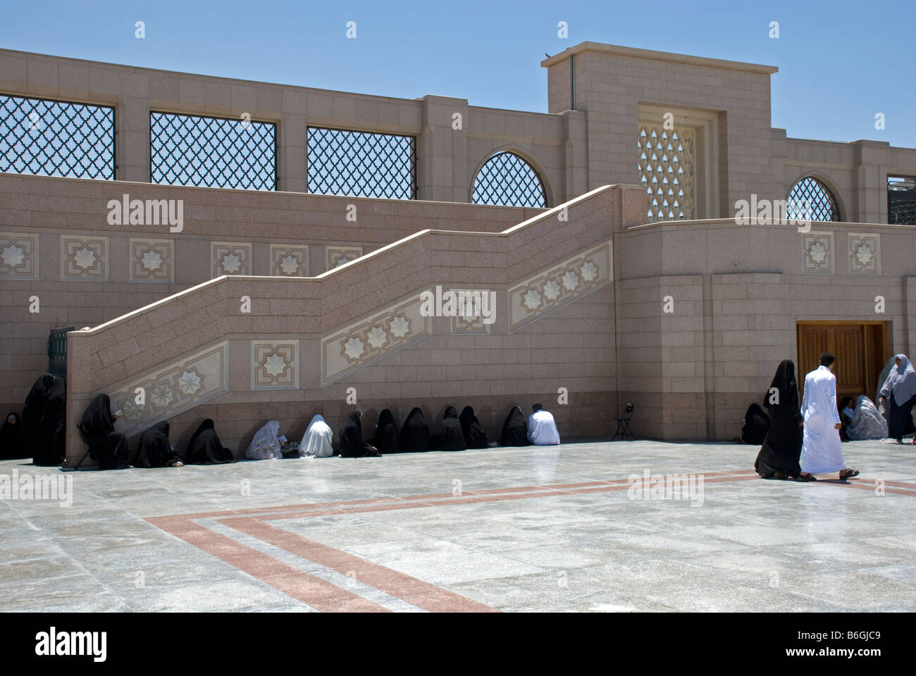 Woman praying in shade in the walls of Jannat Al Baqi Madinah Saudi Arabia Stock Photo