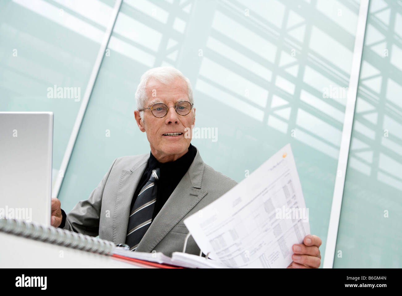 Older man working looking at papers Stock Photo