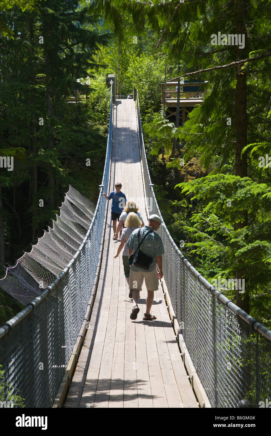 People walking on suspension bridge in forest 'British Columbia' Canada Stock Photo