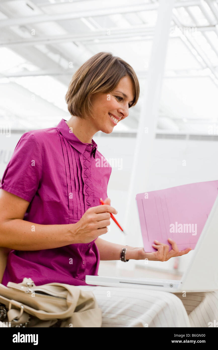 Woman with pen and paper smiling Stock Photo