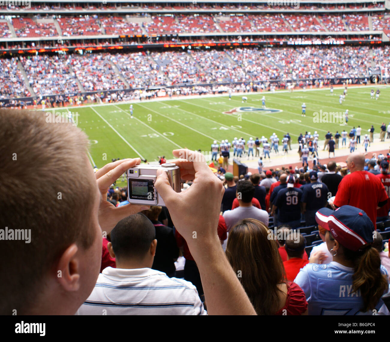 Man taking photograph at football game Stock Photo Alamy