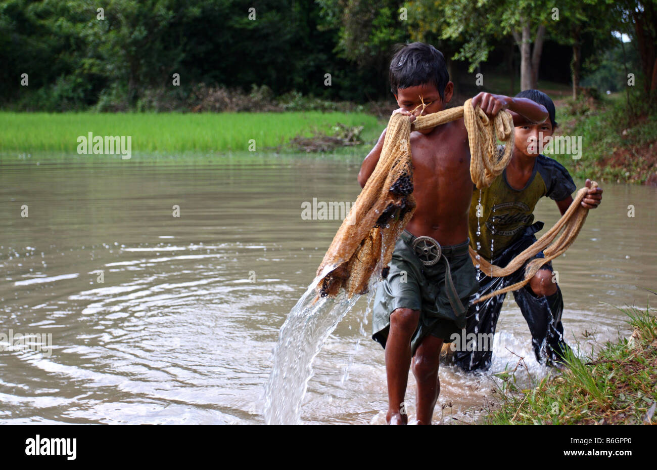 Local young kids fishing casting a net in a pond in the