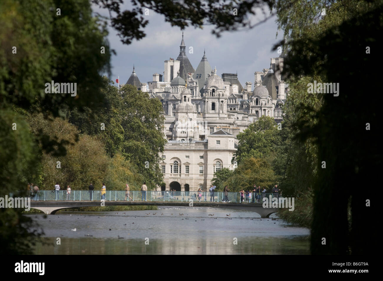 Visitors cross a footbridge in St James's Park  looking towards Horse Guards Parade. Stock Photo