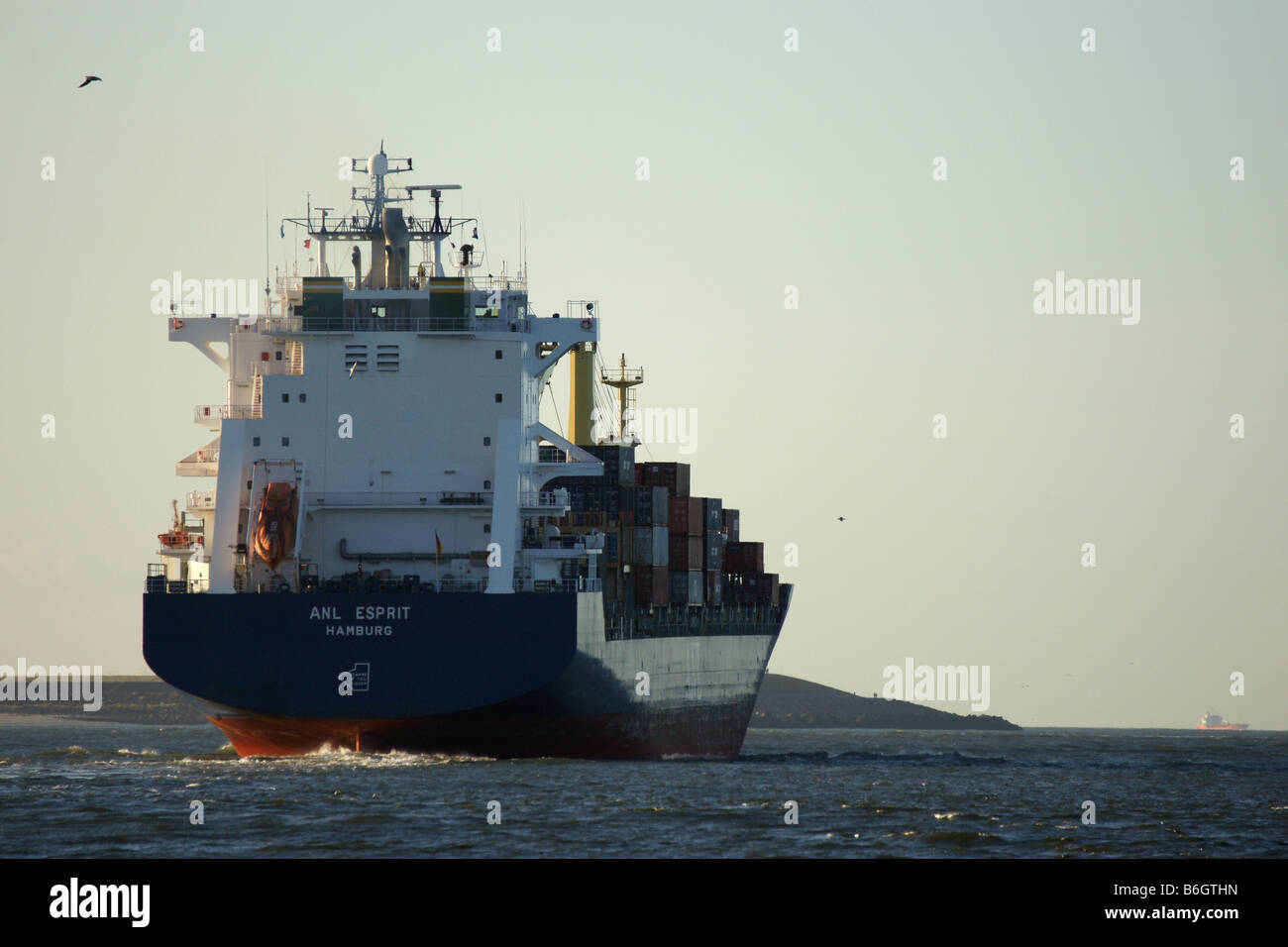 Huge big ship cargo container vessel departing Europoort port harbour Rotterdam Netheralnds sea water horizon back Stock Photo