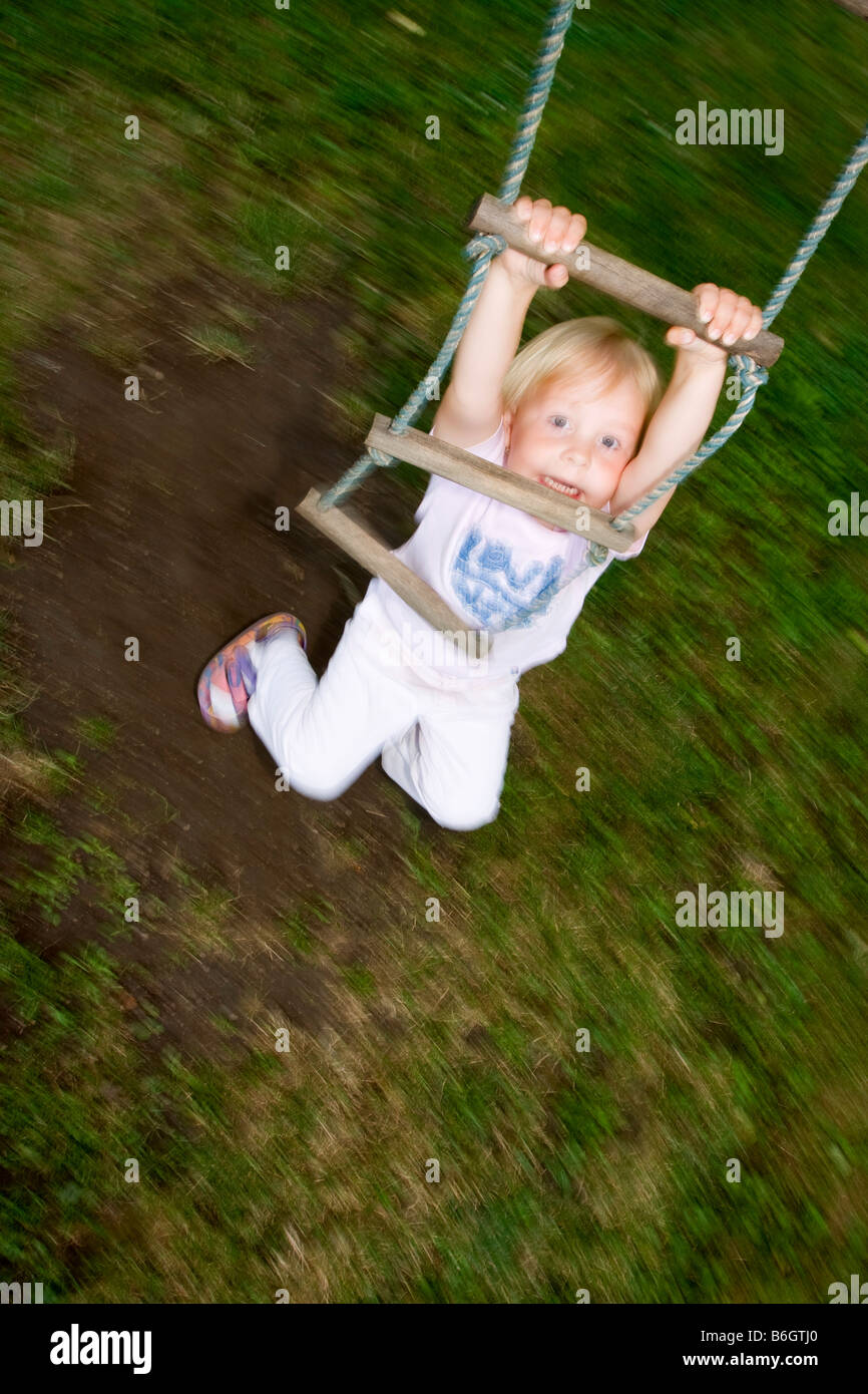 Swinging girl 3 years old Stock Photo