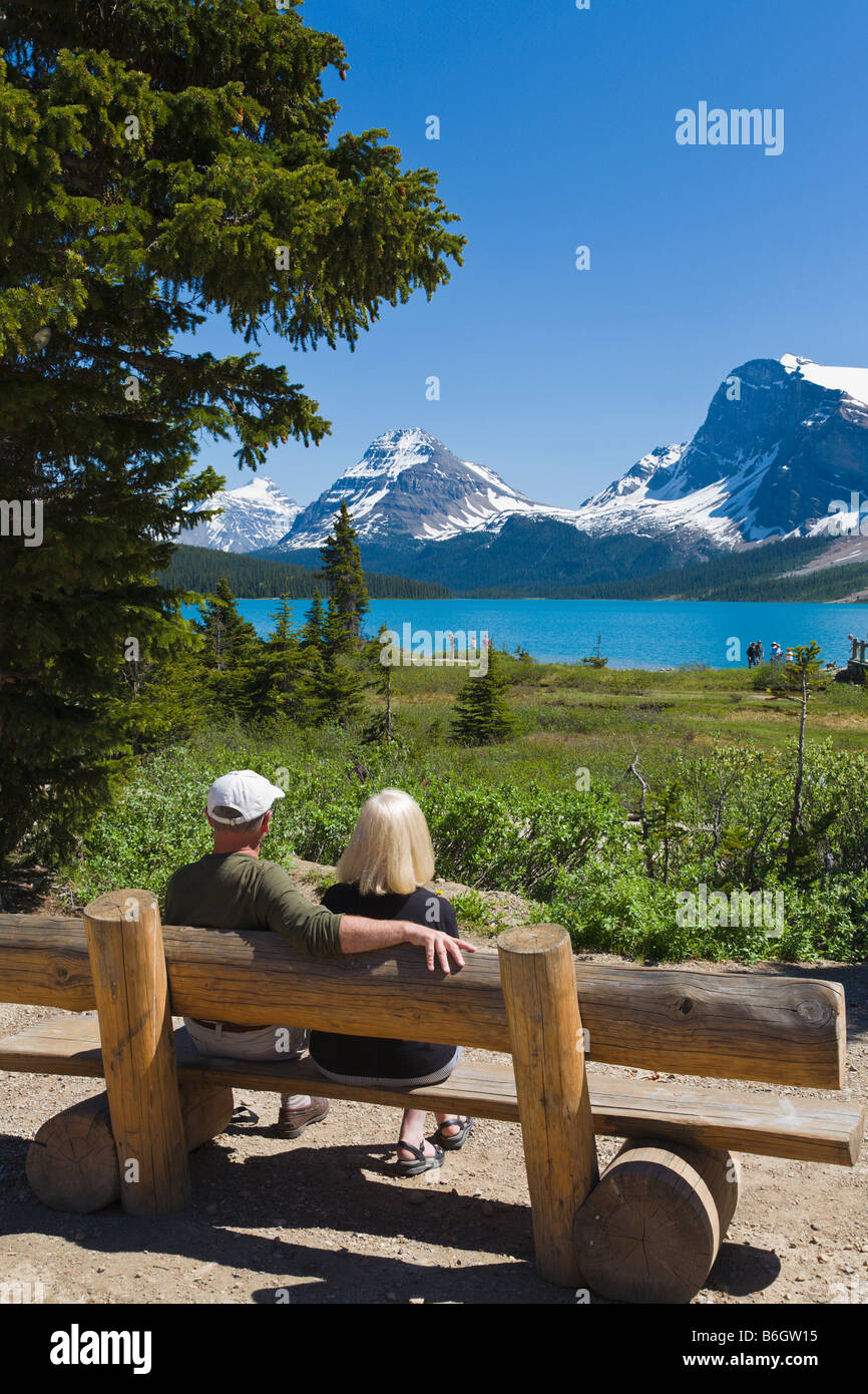 Couple on a bench overlooking Bow Lake Icefields Parkway Alberta Canada Stock Photo