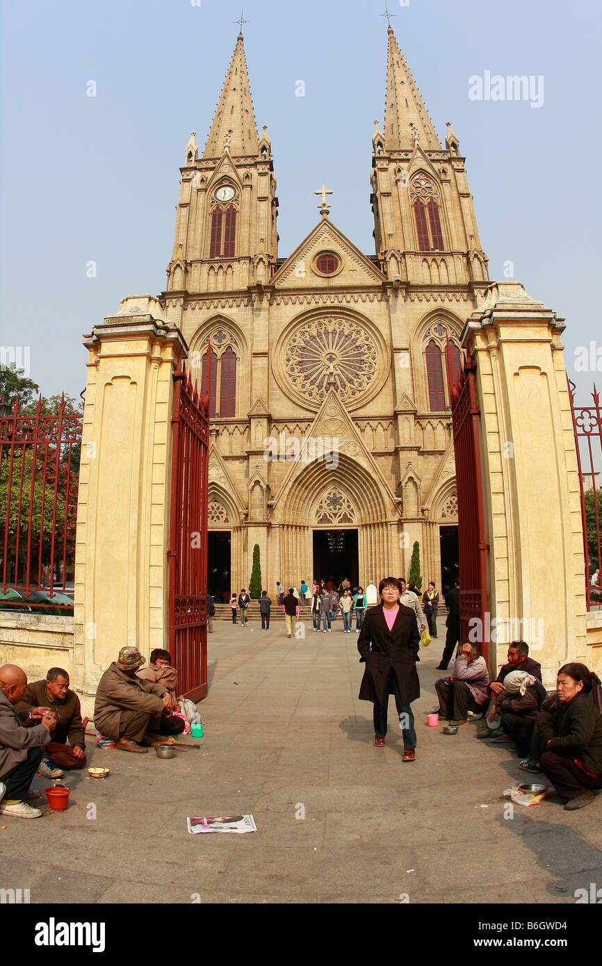 Poverty Stricken CHinese wait outside largest Roman Catholic Cathedral in Asia and ChinaChinese woman leaving Church entrance .. Stock Photo