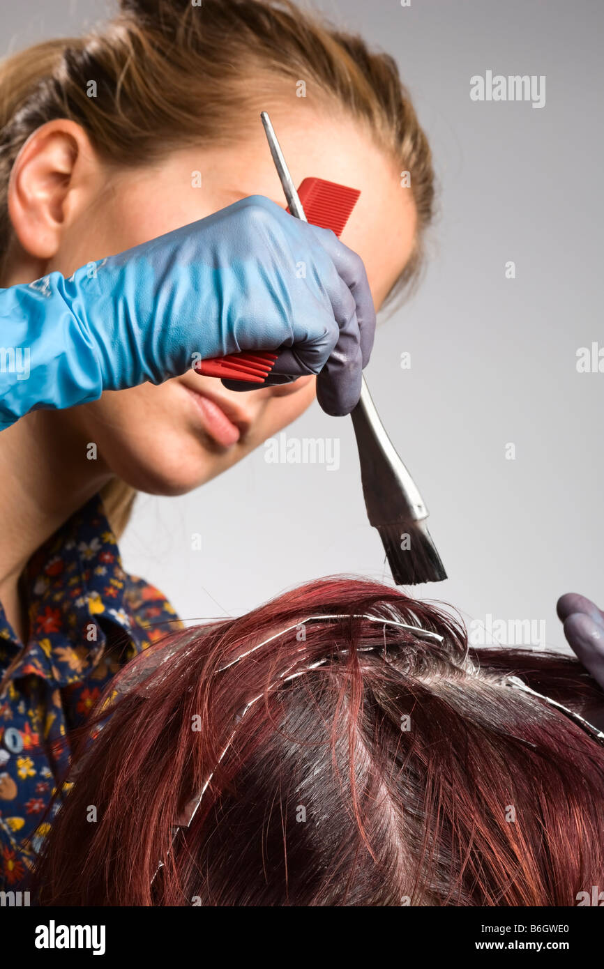 Hair colorist applying color to customer's hair Stock Photo Alamy