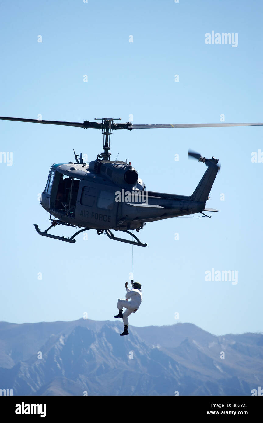 Iroquois Bell UH 1H Iroquois 205 Helicopter and person on winch Warbirds over Wanaka Airshow Stock Photo