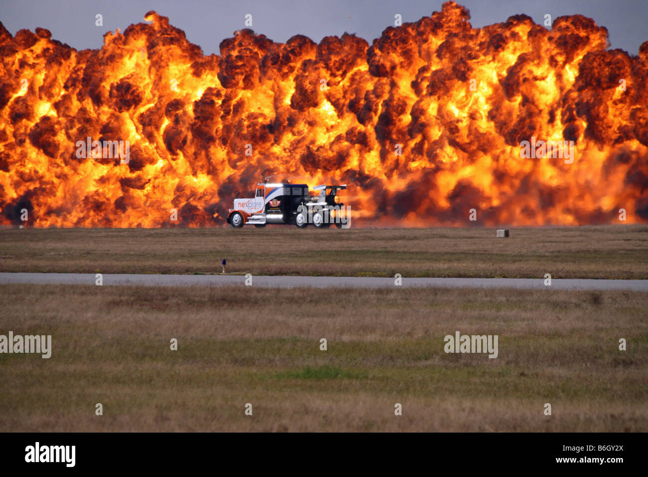 wall of fire and a jet truck blasting through fiery hot flames Stock Photo