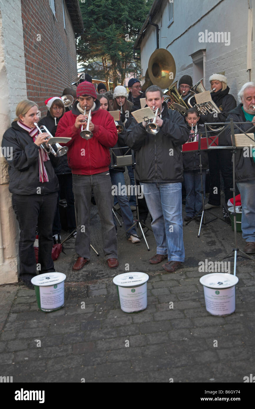 Brass band performing in street at Christmas to collect money for charity Woodbridge Suffolk England Stock Photo