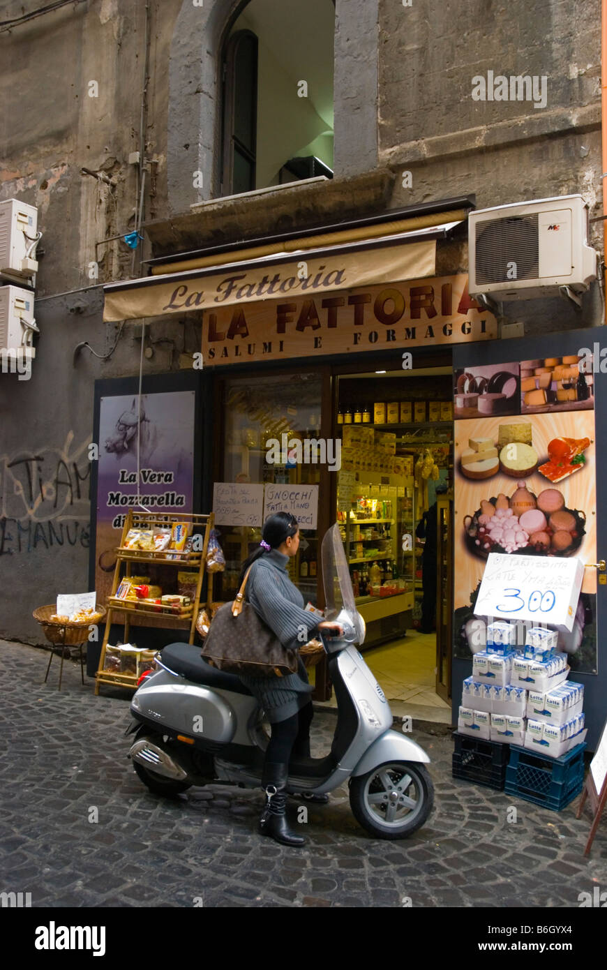 Woman on a scooter in front of a shop along Via dei Tribunali street in  centro storico quarter of Naples Italy Europe Stock Photo - Alamy