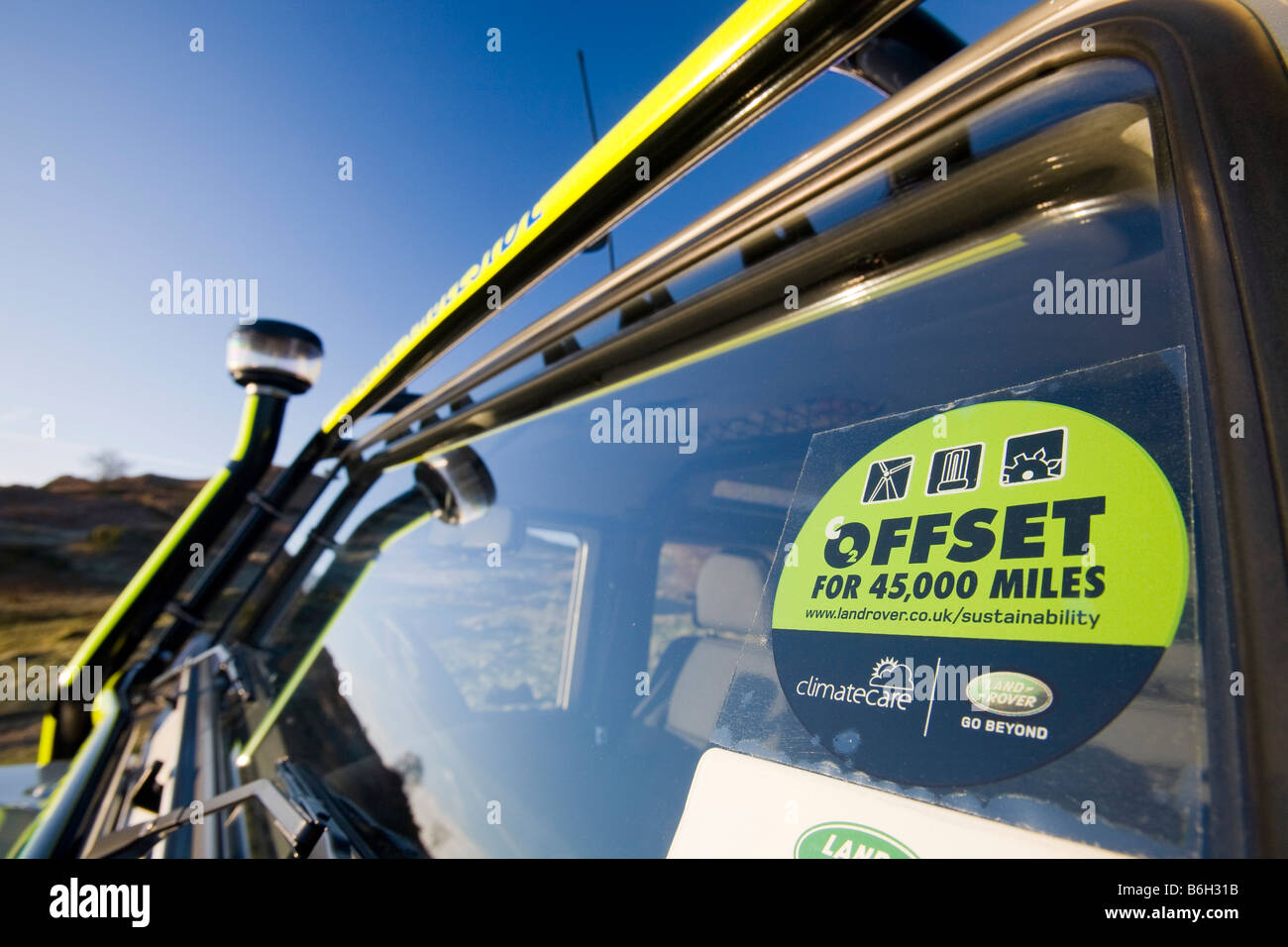 A carbon offset sticker on the windscreen of a mountain rescue landrover Stock Photo