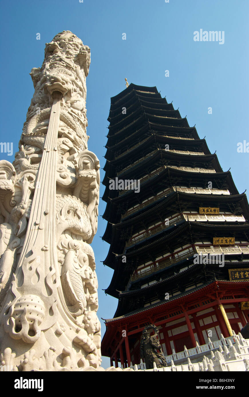 Marble column decorated in sculpted dragons next to the 154 metre Tianning Buddhist  Pagoda tallest in the world Stock Photo