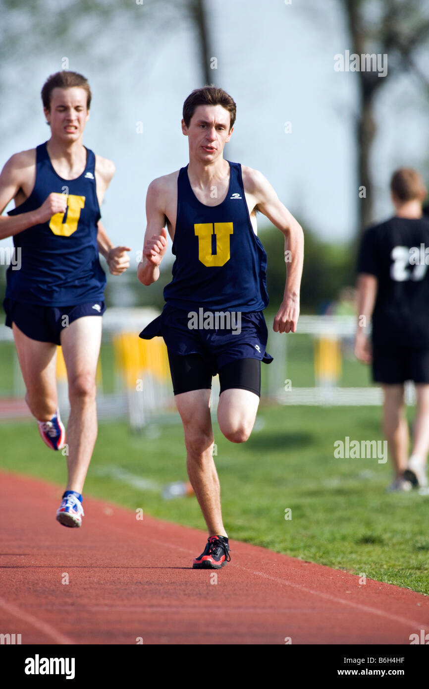 Runners on the track during a high school track & field meet Stock