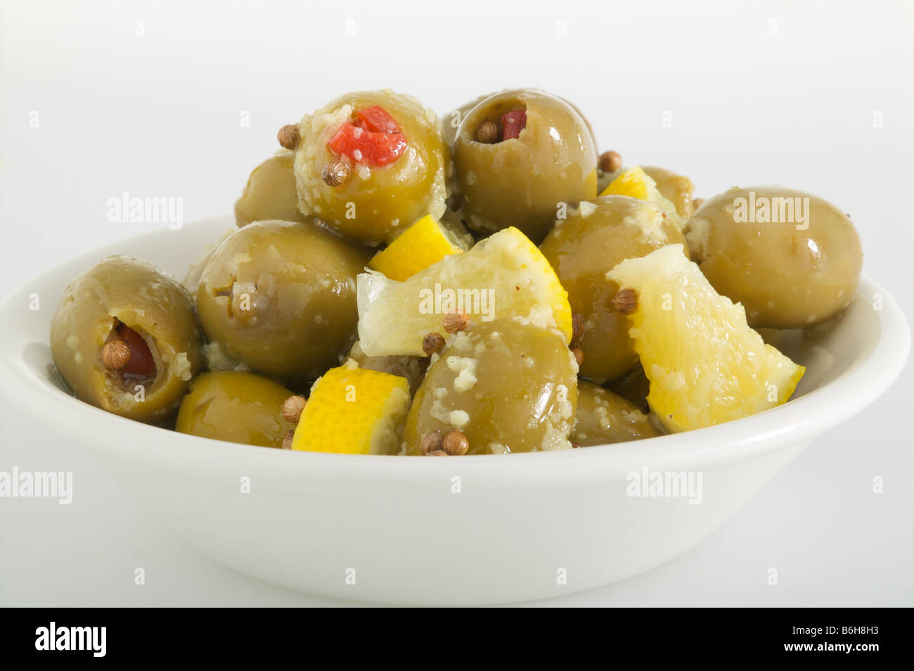 Green Olives stuffed with pimentos with slices of lemon salad on white