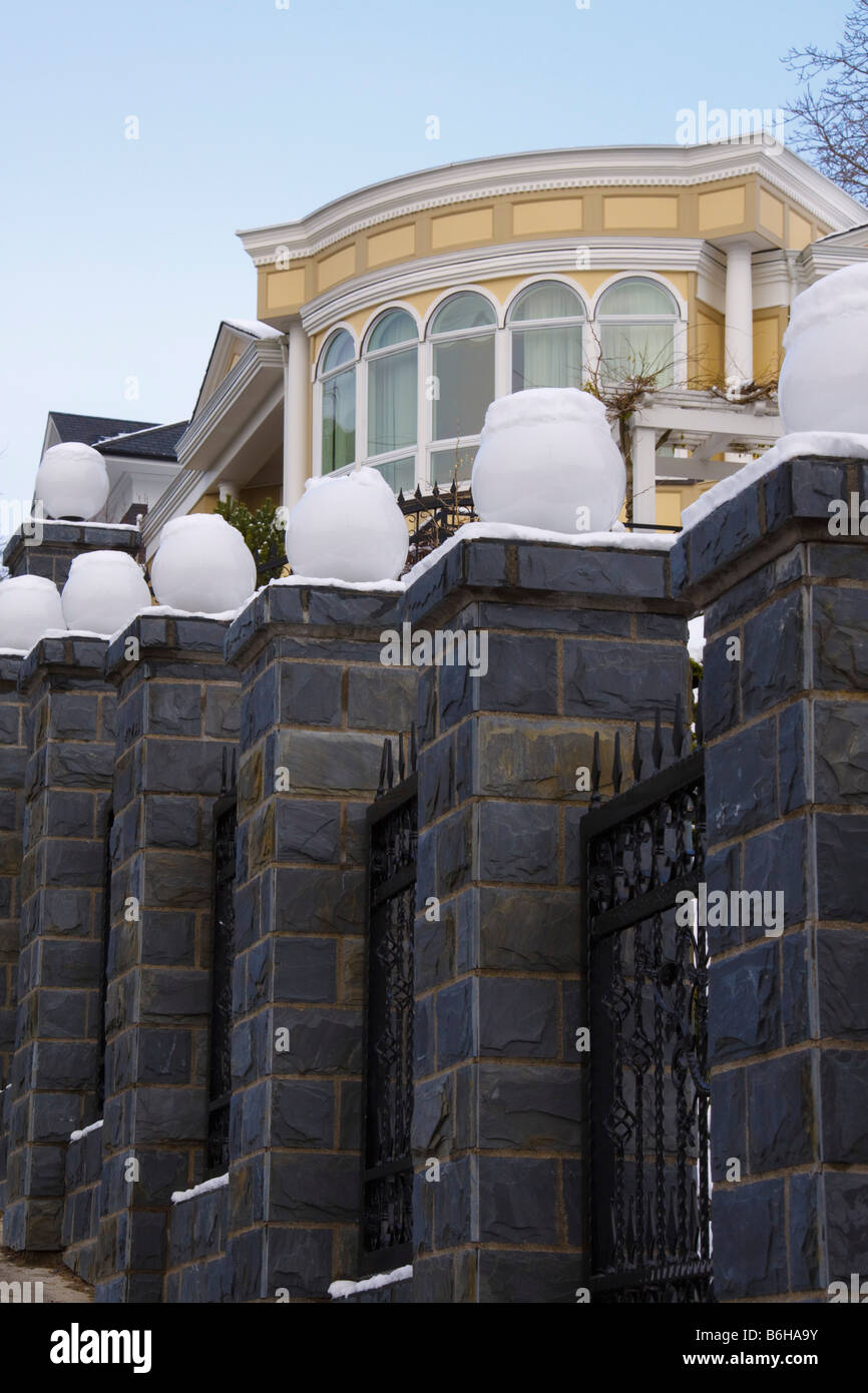 Snow covers white glass globe lights on top of stone fence columns Queen Anne hill Seattle Washington Stock Photo