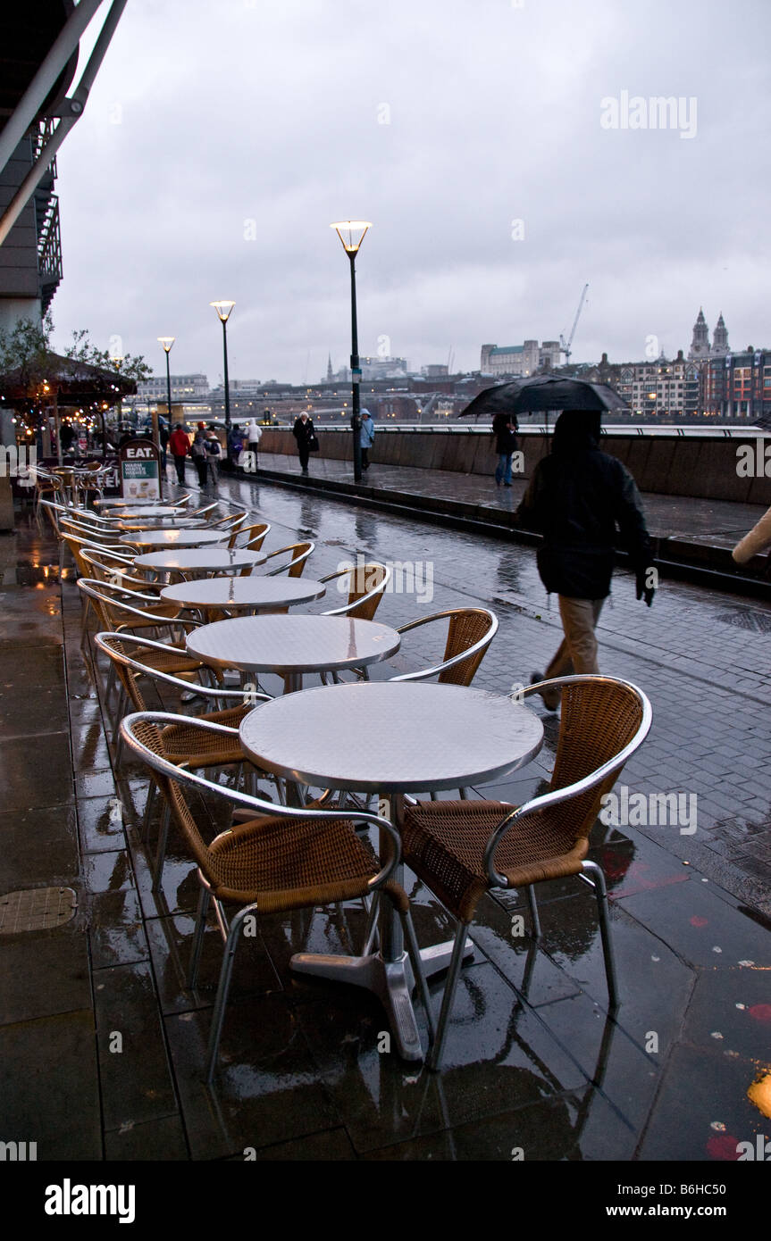 People walking on the South bank on a wet and overcast day. Stock Photo