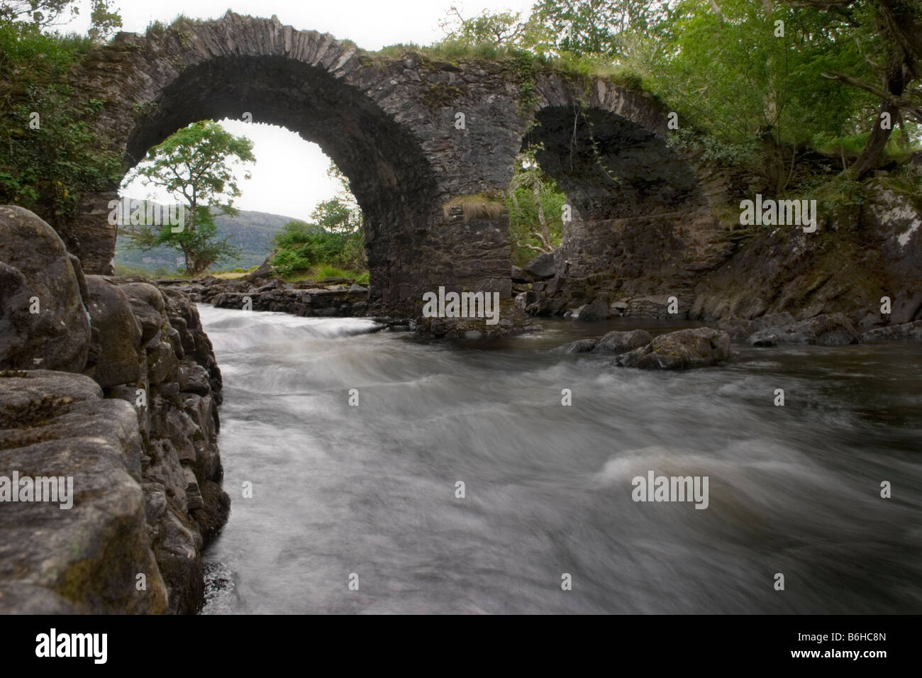 Killarney National Park, County Kerry, Ireland - Near the Meeting of the Waters the water flows fast underneath Old Weir Bridge. Stock Photo