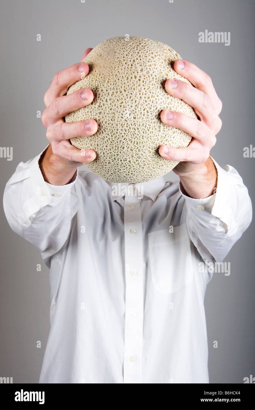 Melon Head A man holding a melon in front of his head Stock Photo Alamy