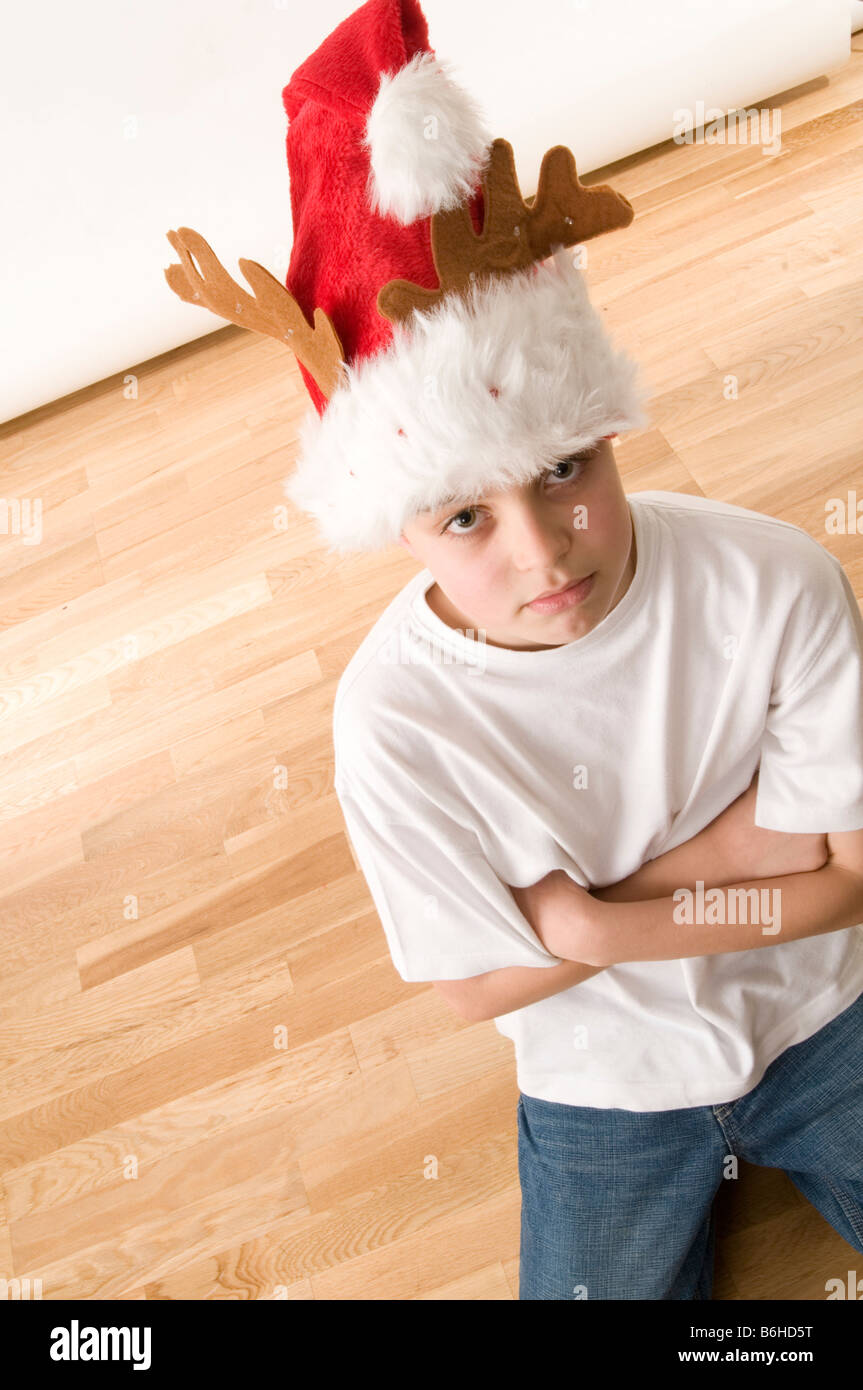 grumpy sad mood moody christmas hat wish wishes santa time child childs kid boy young Stock Photo