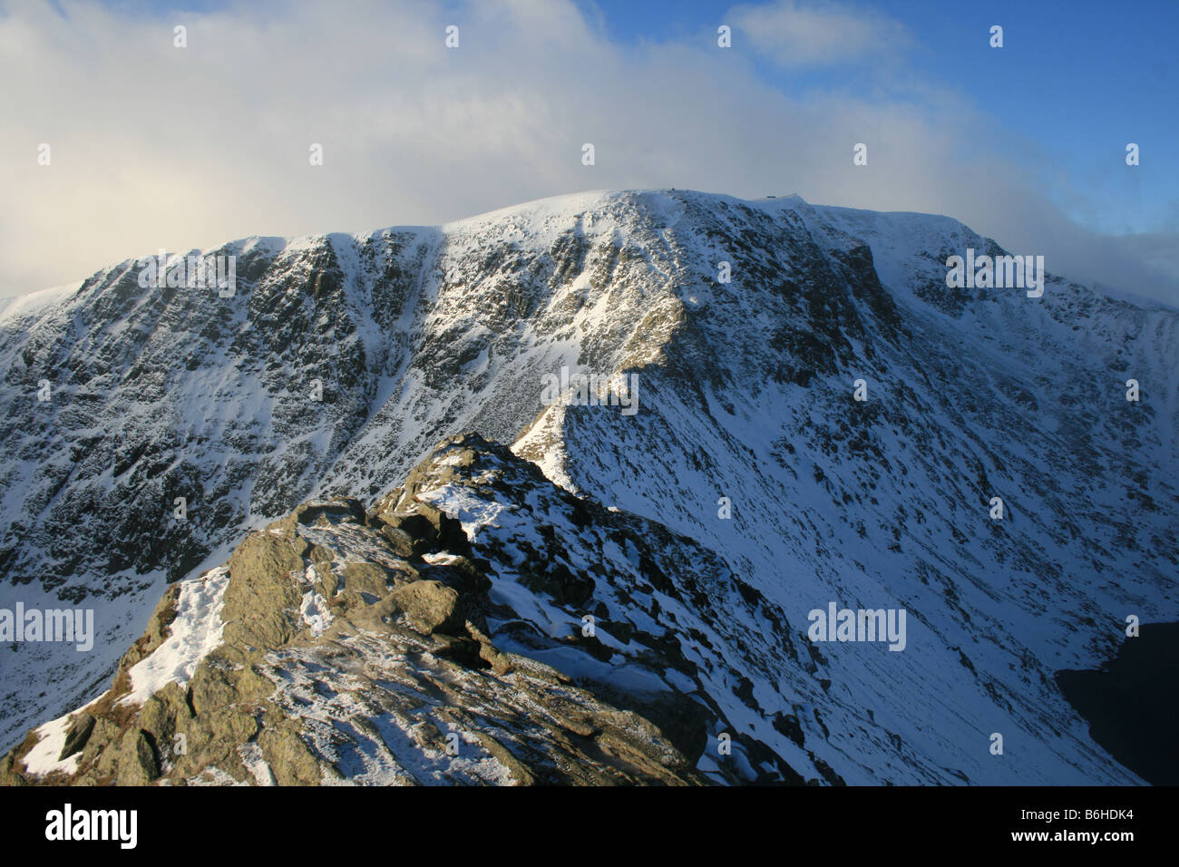 Looking along a wintry Striding Edge towards the summit of Helvellyn, North East Lake District Stock Photo