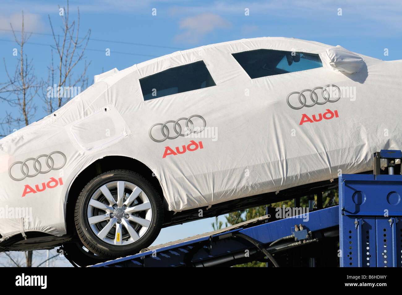 Covered or wrapped Audi car on car carrier for delivery Stock Photo