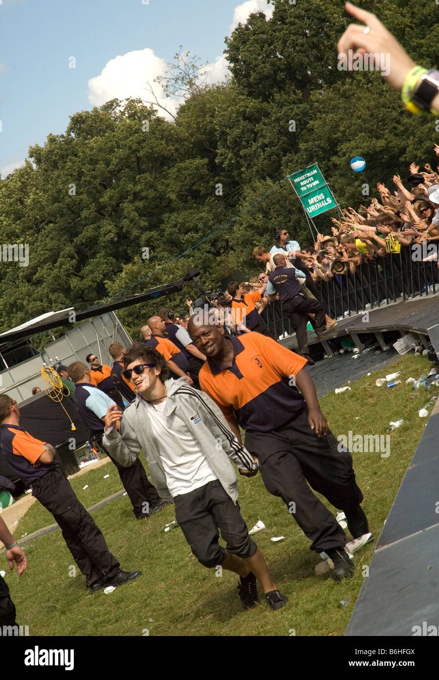 a spectator is escorted out of the arena by security after climbing over the barrier at the 2008 V festival (during the cortinas Stock Photo