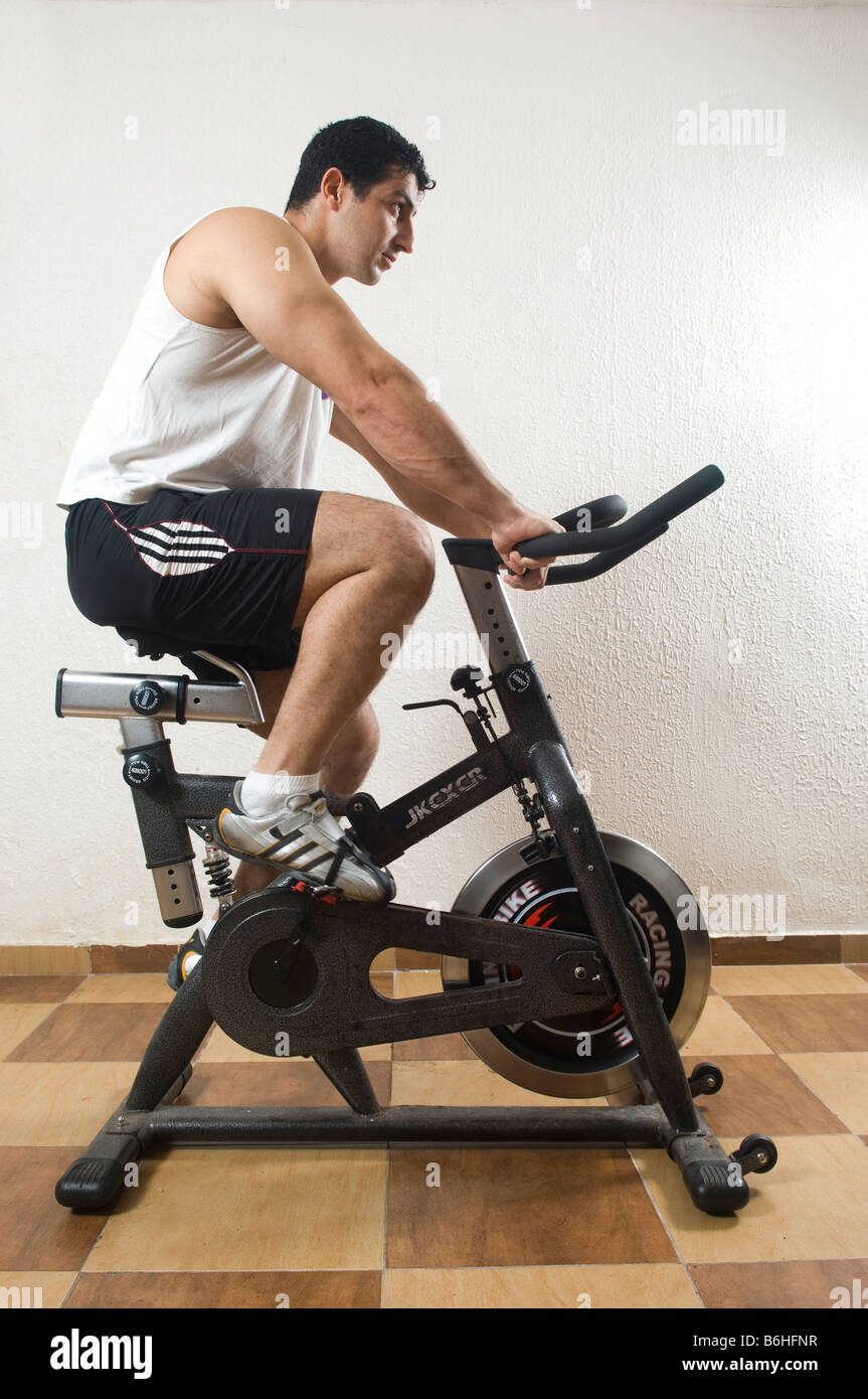 Man cycling on stationary bikes in gym Stock Photo