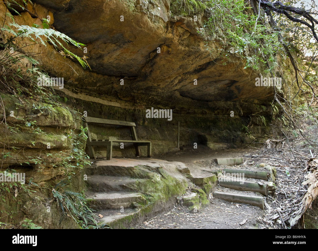 Rickety bench under huge sandstone overhang Stock Photo