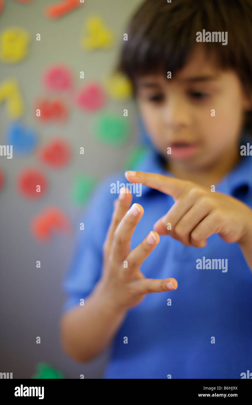 Six year old boy counts on fingers Stock Photo